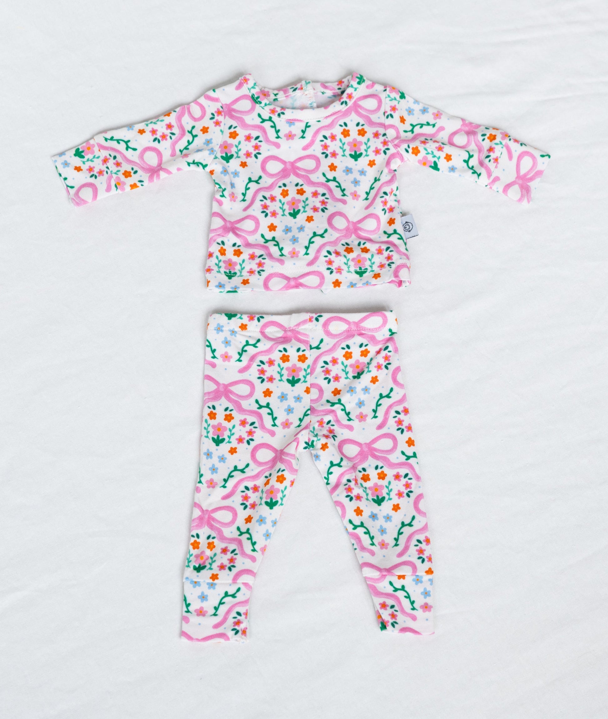 Pink floral doll pajamas on a white background