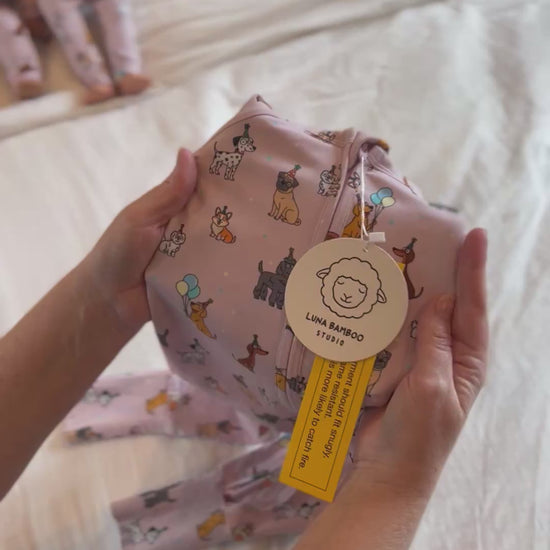 Video of stretch of fabric of Pink bamboo zip sleeper with puppy print for babies and toddlers