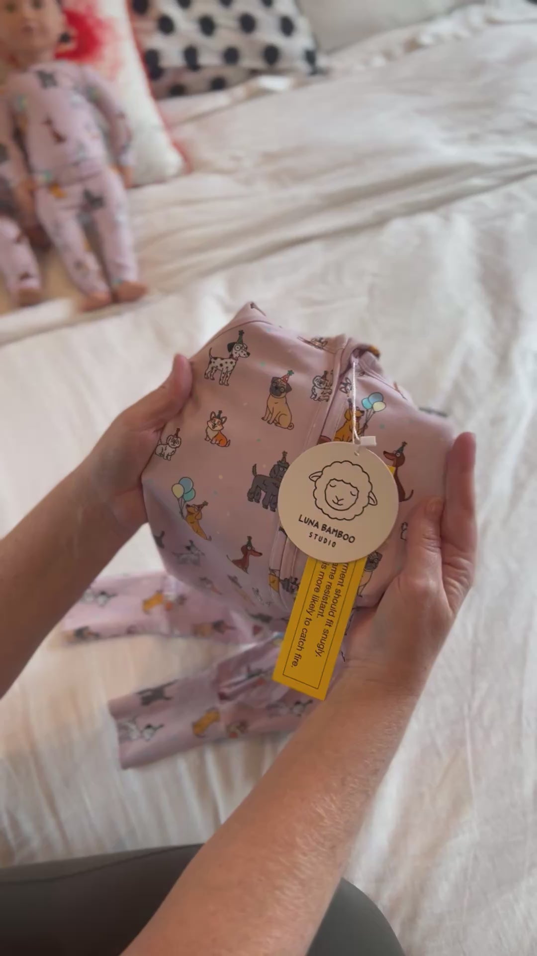 Video of stretch of fabric of Pink bamboo zip sleeper with puppy print for babies and toddlers